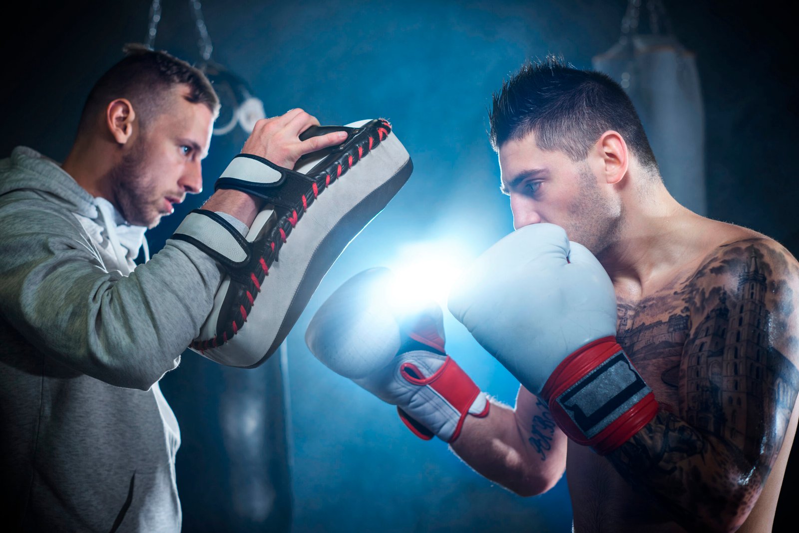 Male boxer sparring with personal trainer