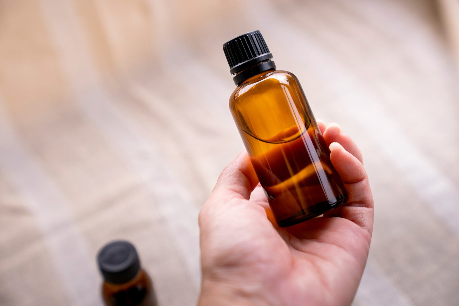 a person holding a bottle of essential oils